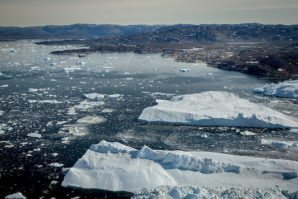Huge icebergs with Ilulissat in the background seen from an Air Zafari flight in Greenland